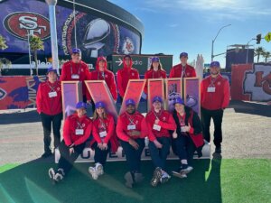 ĻӰ students pose with the Super Bowl LVIII logo in front of Allegiant Stadium in Las Vegas.